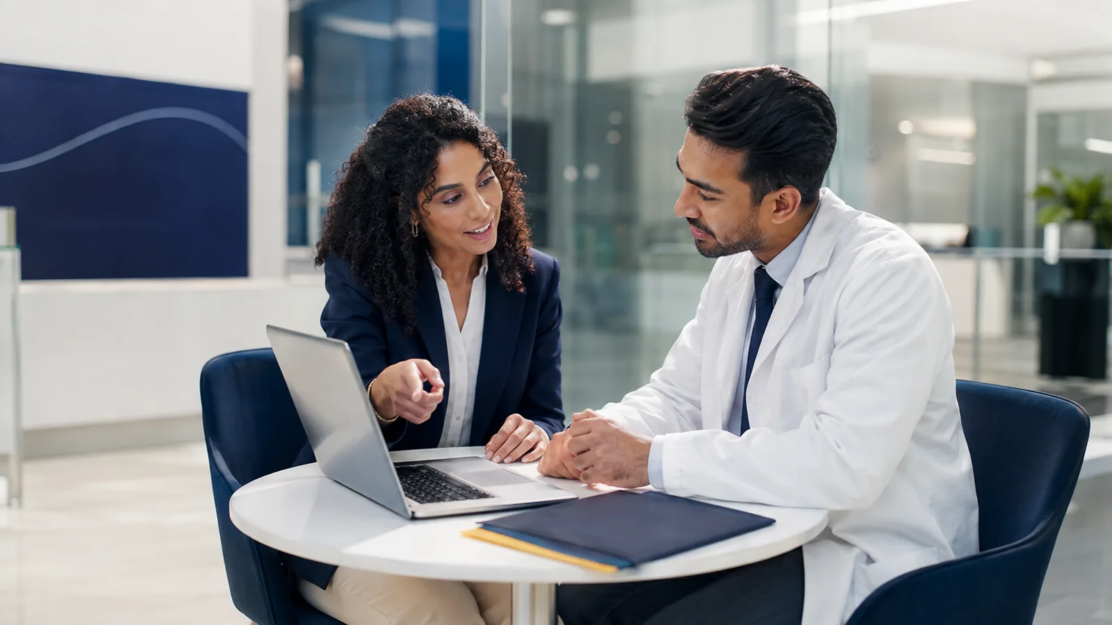 Consultora orientando um médico sobre formações em um atendimento próximo e profissional