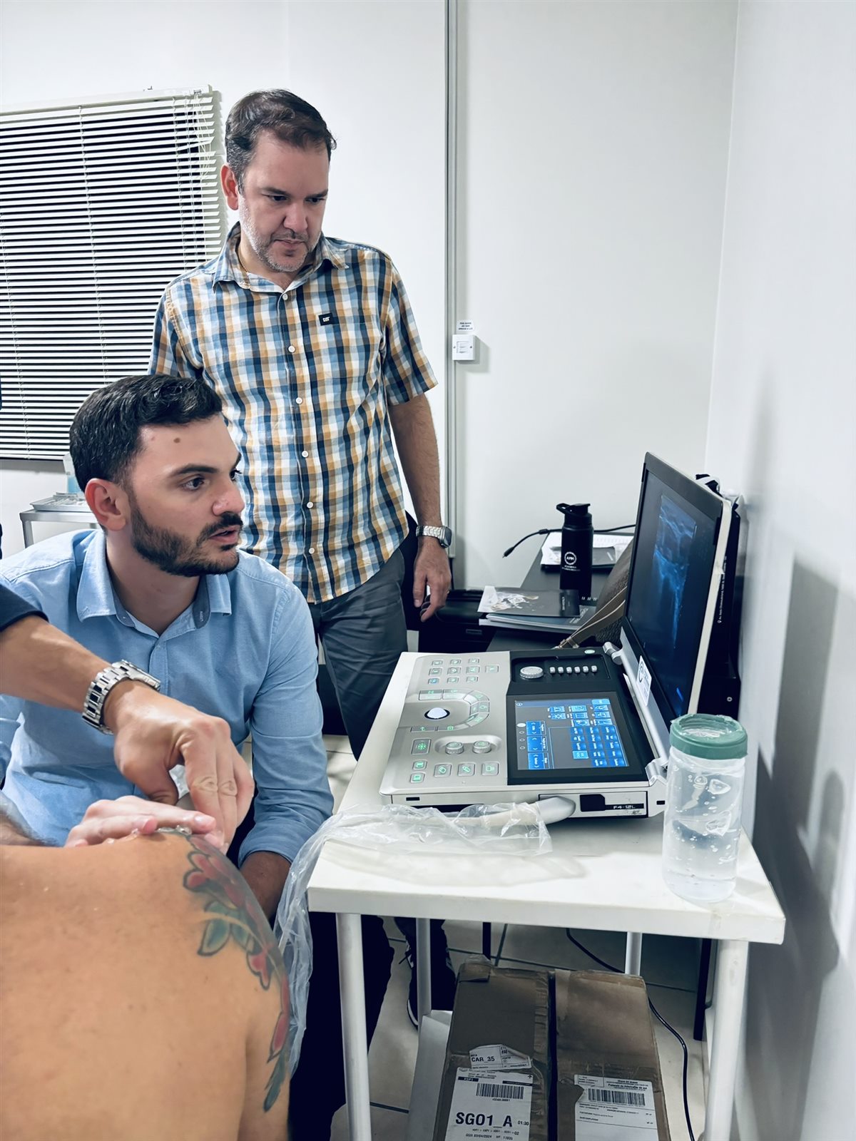 Professor orientando uma atividade prática com equipamento de ultrassom